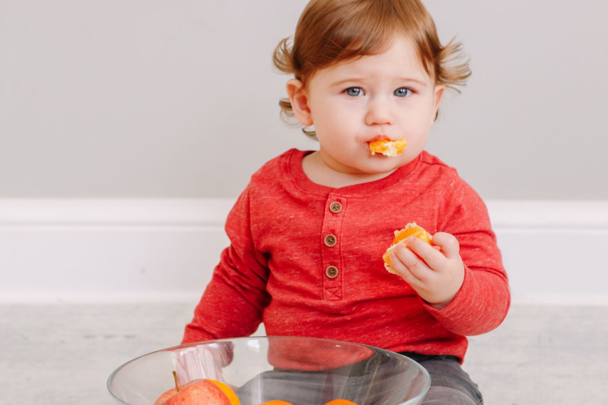 Toddler eating oranges
